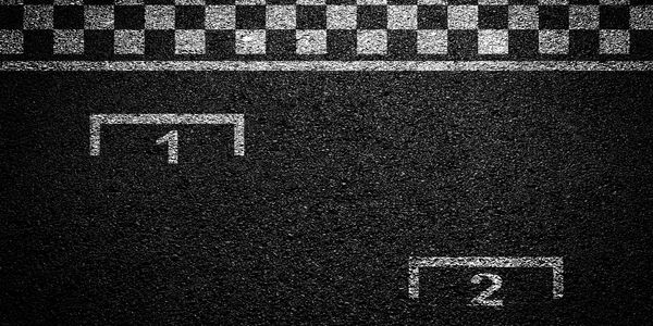 Black and white checkered finish line with numbered starting grid spots on asphalt.