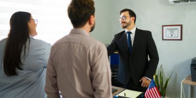 Man shaking hands with woman in office setting.
