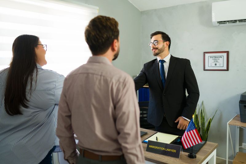 Immigration lawyer providing professional legal advice to a couple, discussing their visa or residency application in an office setting