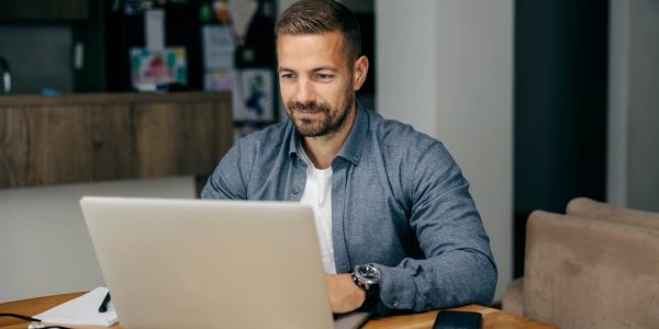 Man working on laptop at a table.