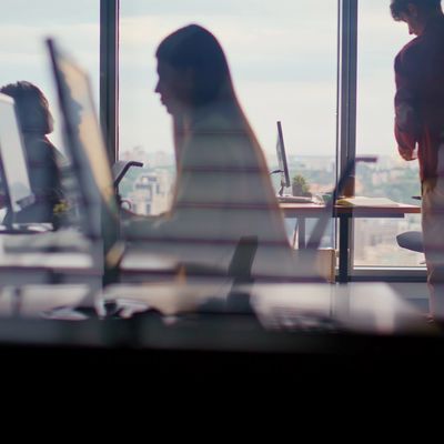 People working in an office with large windows.