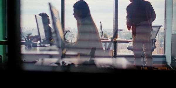 People working in an office with large windows.