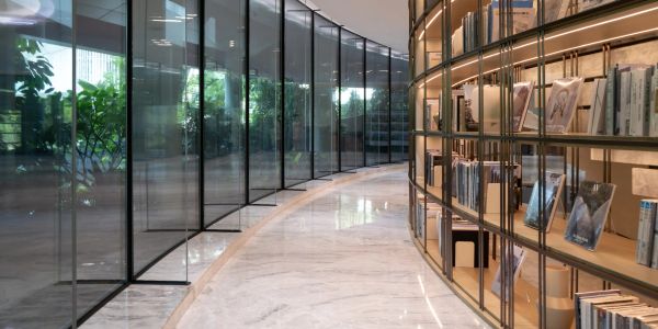Modern library with curved glass and bookshelves.