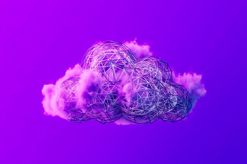 A digitally generated image of a low poly cloud shape prominently displayed on a vibrant purple background, within a futuristic technology background. This abstract and modern design represents cloud computing, digital innovation, and advanced data solutions, combining a minimalist aesthetic with high-tech concepts.