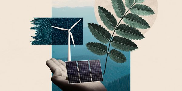 Hand holding wind turbine, solar panels, and leaf symbolizing renewable energy.