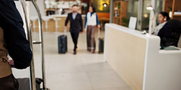 Hotel lobby with guests and receptionist.
