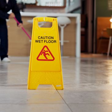 Yellow caution sign warns of wet floor in a clean indoor area.