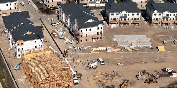 Aerial view of a residential construction site with several houses in progress.