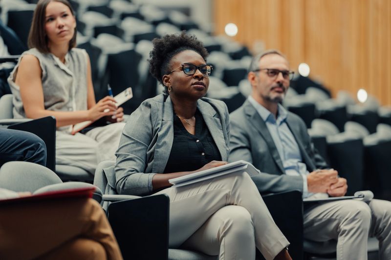 Diverse group of business people listening attentively and learning during a corporate seminar or education event