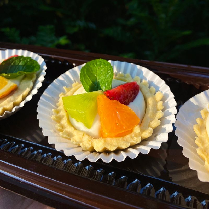 A delightful fruit tart with a buttery, flaky crust filled with creamy custard and topped with an array of fresh, vibrant fruits. Perfectly balanced between sweet and tangy, making it irresistible