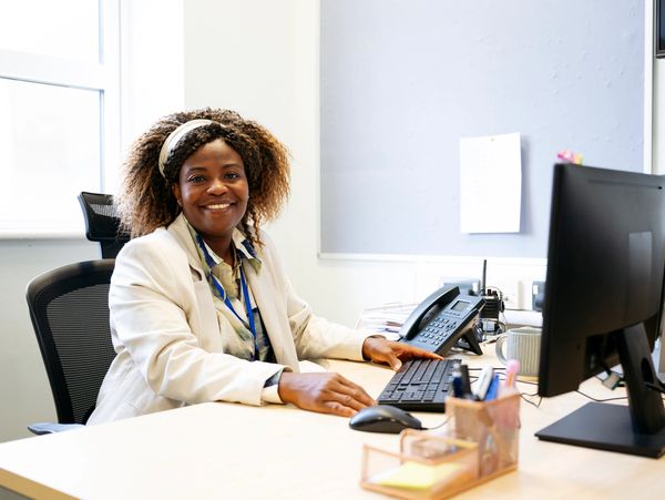 Smiling woman working at her desk in a bright office.