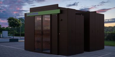 A modern outdoor data center unit at sunset with a colorful sky.
