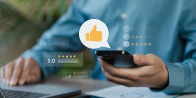 Person using smartphone with floating star ratings and thumbs-up icon.