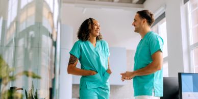 Two healthcare professionals smiling and chatting.