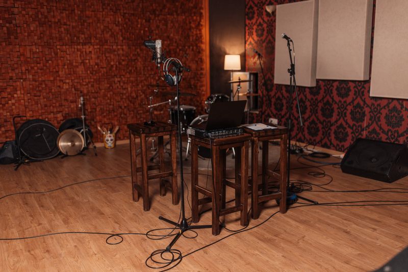 A warm, inviting recording studio featuring various instruments, a microphone setup, and a comfortable atmosphere ideal for music creation and collaboration.