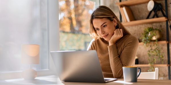 Mujer trabajando concentrada en una laptop.