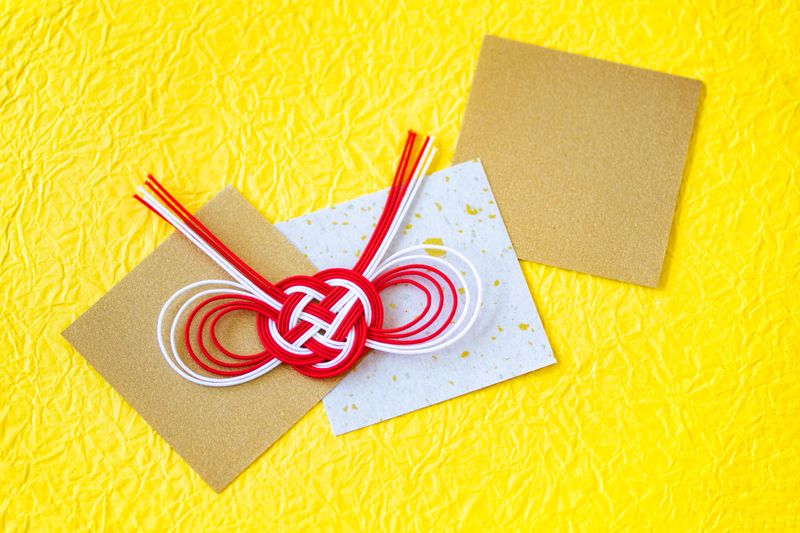 Japanese New Year's images. Chiyogami and mizuhiki with Japanese paper.  / yellow background.