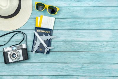 Travel essentials including camera, sunglasses, passport, and tickets.
