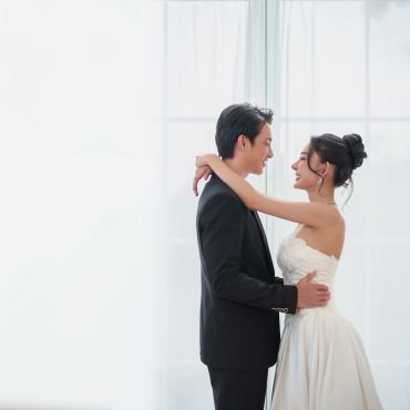 Couple in wedding attire embracing each other.