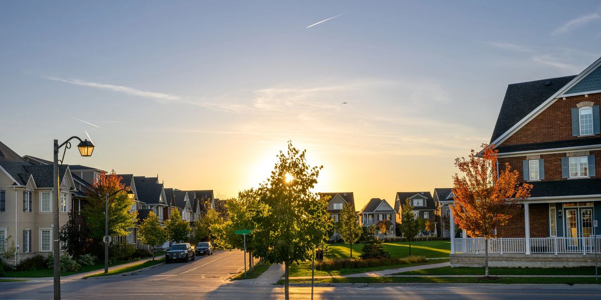Sunset over a suburban neighborhood with houses and trees.