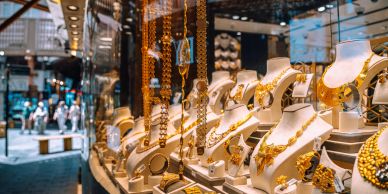 Jewelry store window display with gold necklaces.