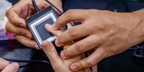 Person using fingerprint scanner for identification.