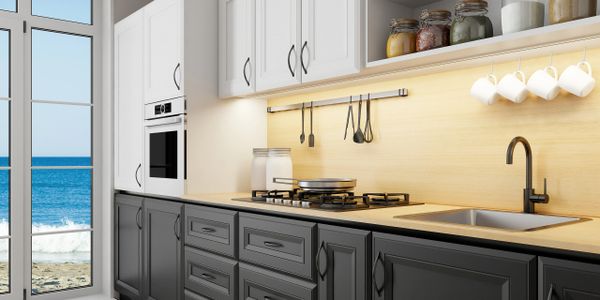Modern kitchen with black and white cabinets overlooking the ocean.