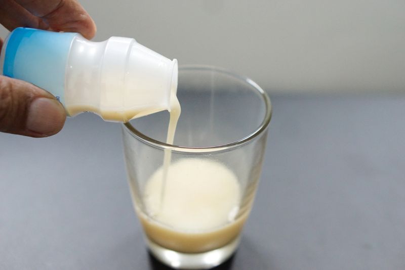 Pouring a probiotic drink, the benefits of probiotic drinks include supporting gut health and boosting the immune system.