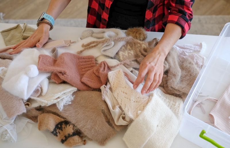 Close-Up Of Woman Organizing Knitted Baby Clothes