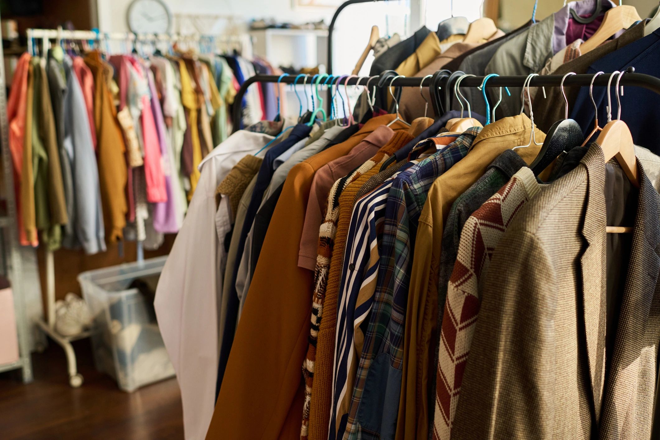 Clothes hanging on racks in a store or closet.