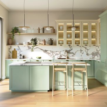 Modern kitchen with light green cabinets and marble backsplash.