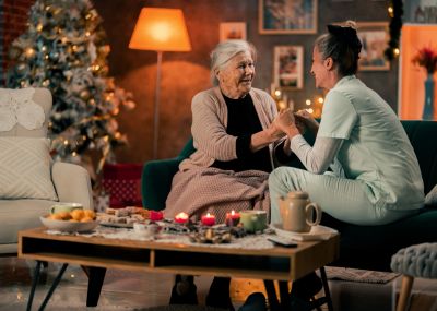 Elderly woman and caregiver share a warm moment at home.