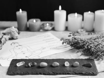 Healing crystals arranged with candles and dried herbs.