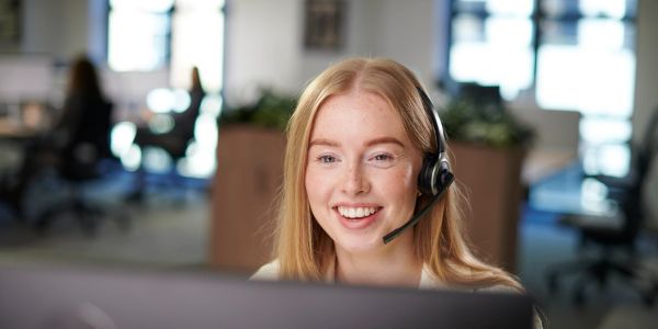 Smiling woman wearing headset in office.