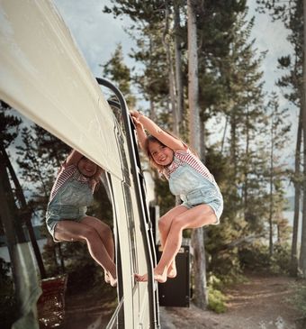 RV driving on a winding road through a desert landscape with large rock formations.