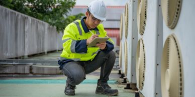 Técnico inspecciona unidades de aire acondicionado con tableta.