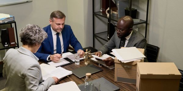 Três advogados discutindo documentos.