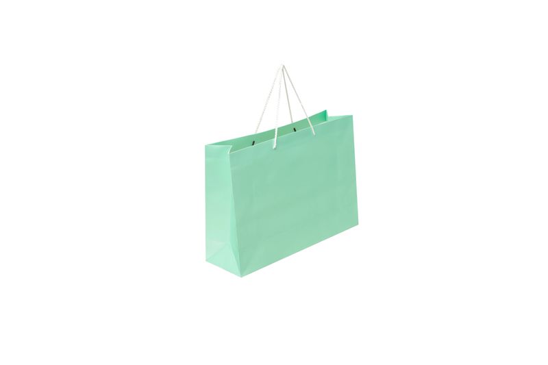 A blank, horizontal recycled kraft paper shopping bag with matching rope handles folded at the top. The side and bottom of the bag are slightly visible. Ideal for use as a mockup background to display a logo or design, clearly isolated on a clean white background Isolated.