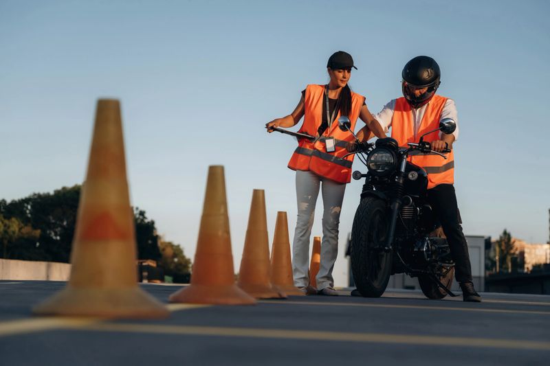 Many of the cones. Motorcycle driving license exam. Man and woman are in uniforms.