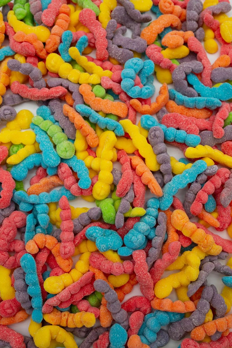 Sugary sour gummy worms creating a vibrant and playful full frame background