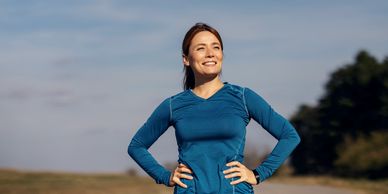 Smiling woman in blue athletic wear outdoors.