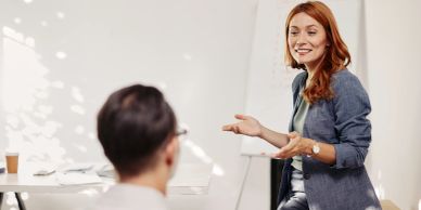 Woman presenting to a man in an office setting.