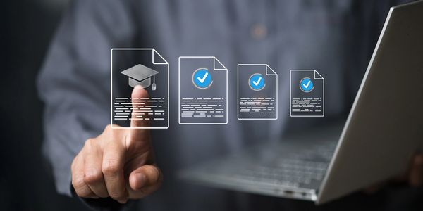 Person selecting a digital graduation certificate icon on a transparent screen with a laptop.