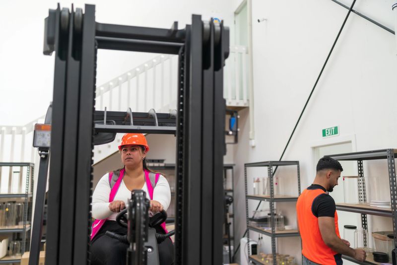 A skilled warehouse forklift operator moves goods through a distribution center, helping maintain efficient logistics and inventory flow.