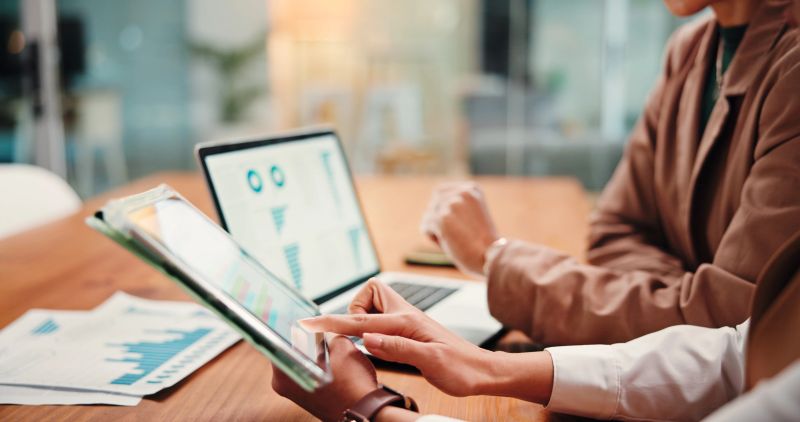 Hands, people and graphs on tablet in office for finance results, profit growth and budget review. Employees, team and digital with financial report, revenue stats and comparison for risk assessment