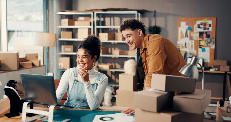 Happy, fashion and logistics team with laptop in office for online order, client feedback or sales. Small business, boxes and people with tech for delivery tracking, inventory management and shipping