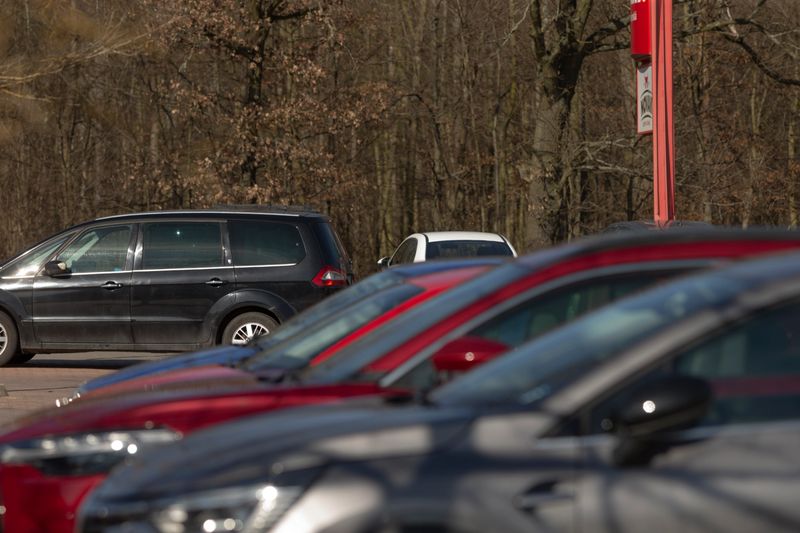 diverse cars displayed prominently, showroom vehicles with colorful and bright appearance, wide selection of vividly colored cars displayed prominently in dealership showroom with sunlight shining