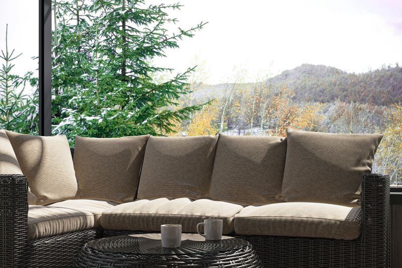 Stylish outdoor terrace of a luxury villa house featuring natural wood paneling, long wooden flooring, and modern rattan furniture with soft beige cushions. Surrounded by lush greenery and forest views, this Scandinavian-inspired design blends comfort and elegance, ideal for relaxation, vacation homes, or architectural and lifestyle concepts.
