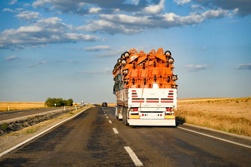 A truck transporting cargo in a dry cargo semi-trailer moves along the highway along the mountains