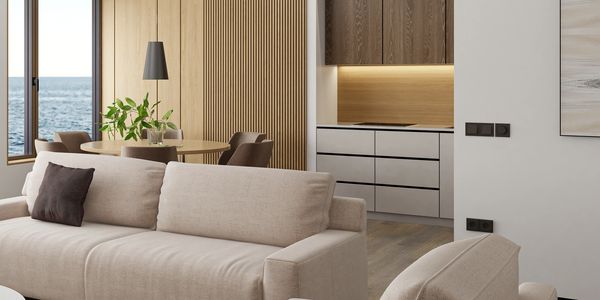 Modern living room with beige sofas and ocean view.